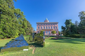 A large building with a central dome, surrounded by a well-maintained garden with a pathway leading to the entrance. - Star of Lugano (Lugano)