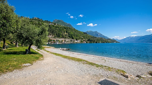 A lakeside path leading to a dock, surrounded by greenery and mountains. - Borgo Degli Ulivi shared pool- 200m lake (Toscolano Maderno)