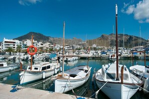 A marina with several boats docked, a lifebuoy, and buildings in the background. - Modern house with 3 bedrooms, 2 bathrooms, wifi, terrace and barbecue 100 meters from the beach (Puerto de Alcudia)