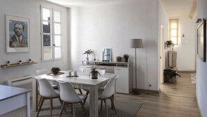 Una cocina moderna con armarios blancos, una mesa de comedor con sillas y una pequeña isla con plantas.