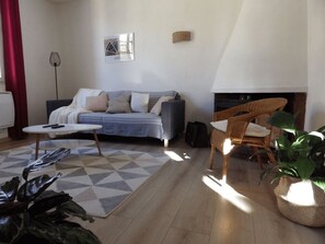 A living room with a sofa, a coffee table, a fireplace, and a chair.