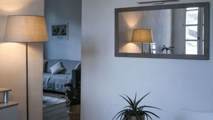 Una habitación acogedora con cama, escritorio, silla, mesa y una planta en maceta.