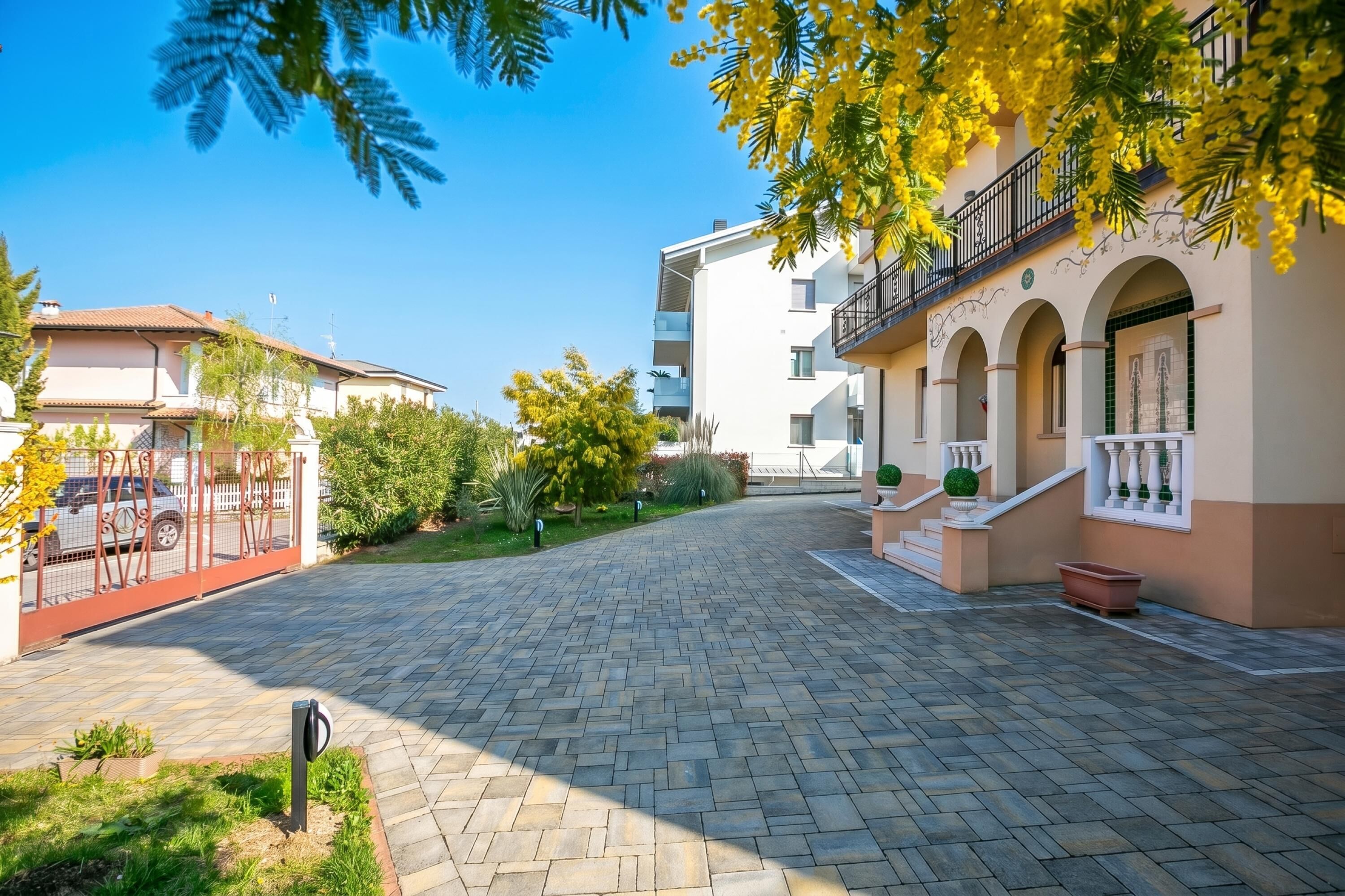 Ein gepflasterter Innenhof mit einem Gebäude mit Balkonen und Rundbogenfenstern.