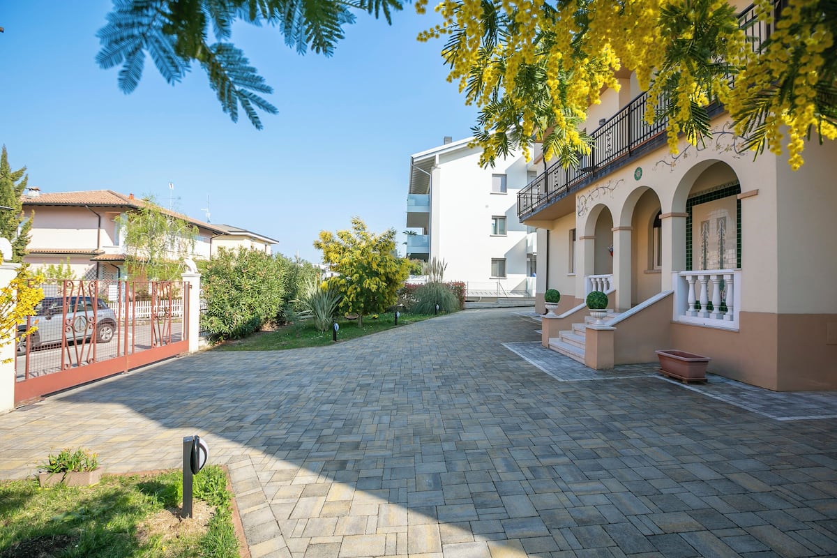 Ein gepflasterter Innenhof mit einem Gebäude mit Balkonen und Rundbogenfenstern.