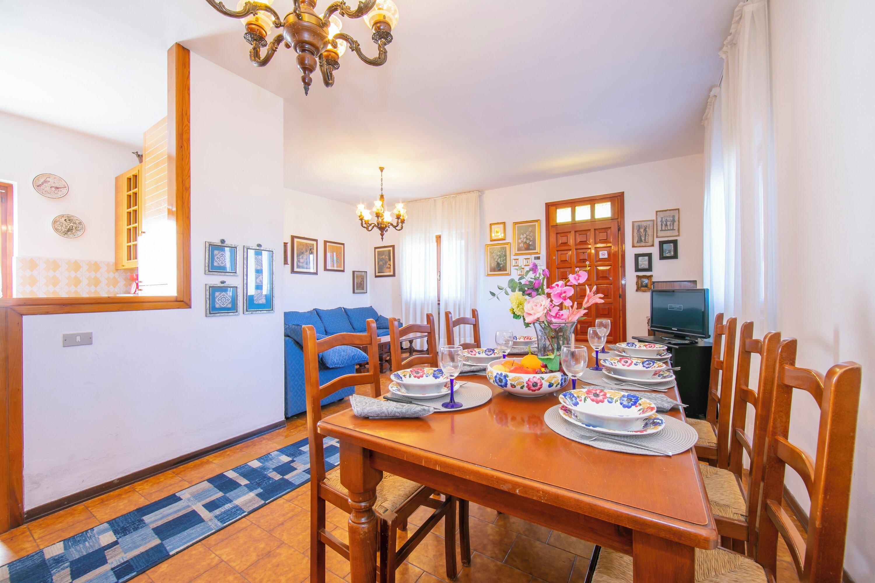 Un comedor con una mesa de madera dispuesta para una comida, rodeada de sillas.