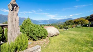 Una escultura de madera en un jardín con vistas a la montaña.