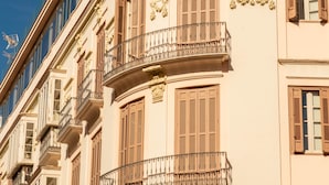 Un edificio de varios pisos con balcones y ventanas amplias.