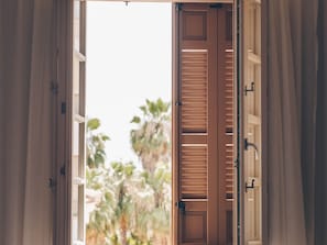 An open wooden door with a view of palm trees outside. - Alcazaba Premium Hotel (Málaga)