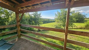 Une terrasse en bois offrant une vue sur un paysage verdoyant.
