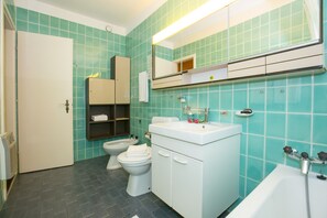 Tina con regadera, secadora de cabello, bidet, toallas 