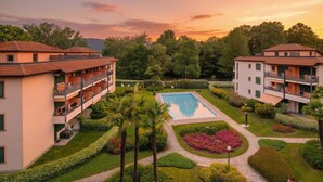 Un hôtel doté d’une piscine, de jardins luxuriants et de nombreux balcons.