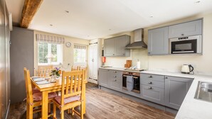 A modern kitchen with grey cabinets, a built-in oven, and a microwave.
