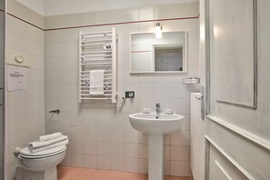 A bathroom with a toilet, a sink, a towel rack, and a mirror. - Berny Salo: Near the Lake & Garage (Salò)