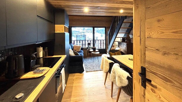 Una cocina moderna con detalles de madera, un comedor con vistas y un espacio de descanso acogedor.