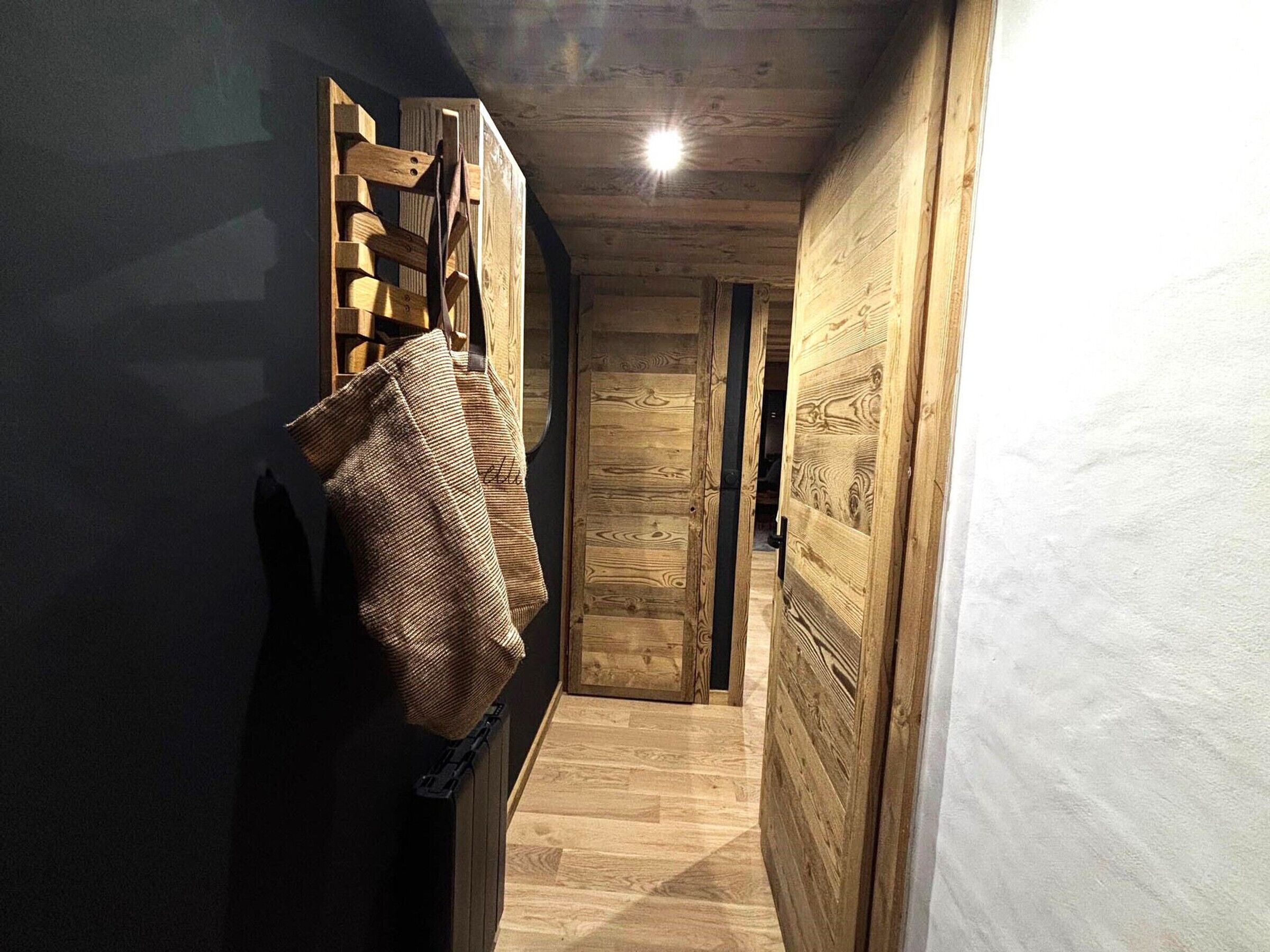 Un couloir aux murs en bois et doté d’un radiateur.