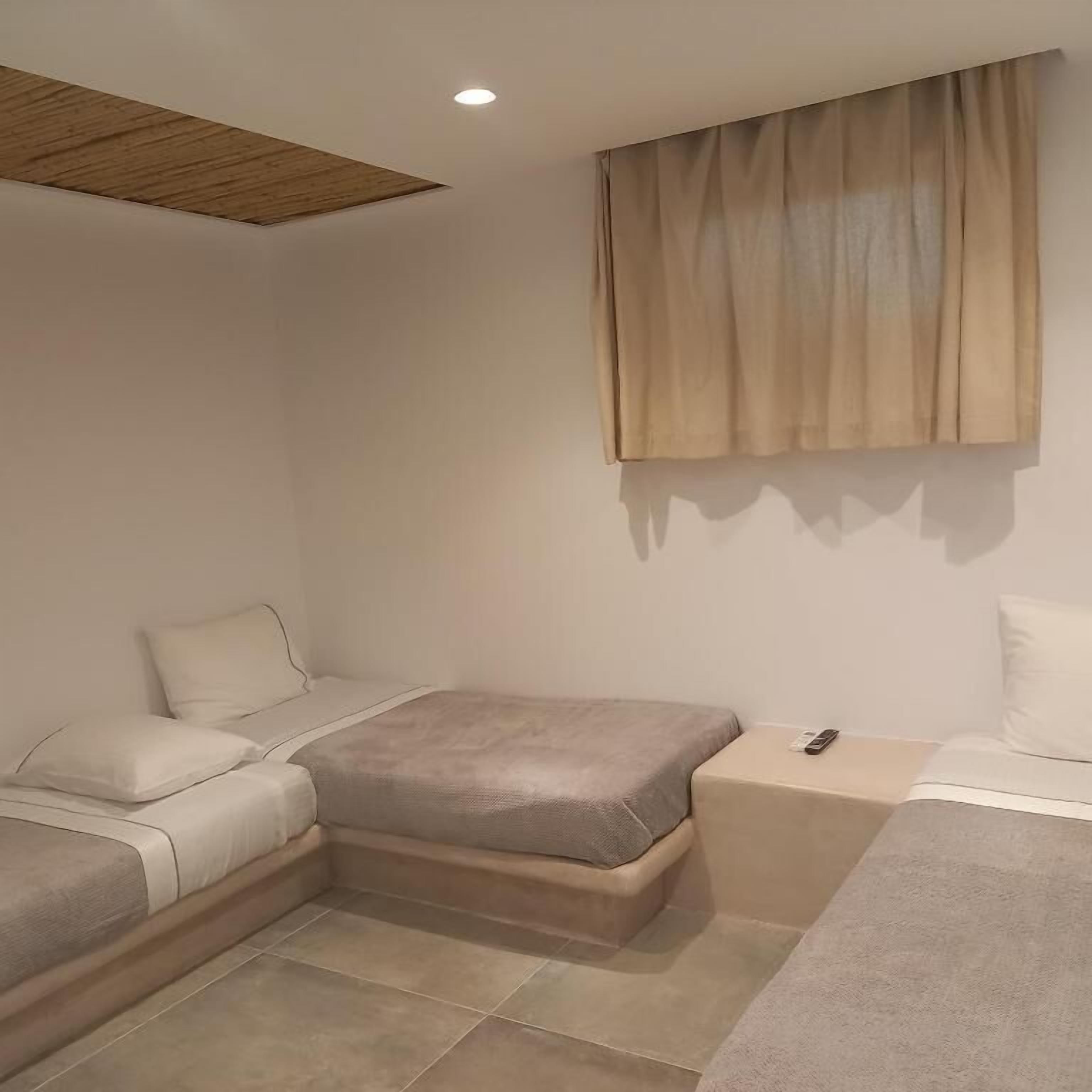 Um quarto moderno com cama, mesas de cabeceira e luminária no teto.