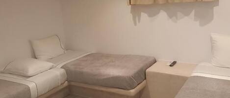 A modern bedroom with a bed, bedside tables, and a ceiling light.
