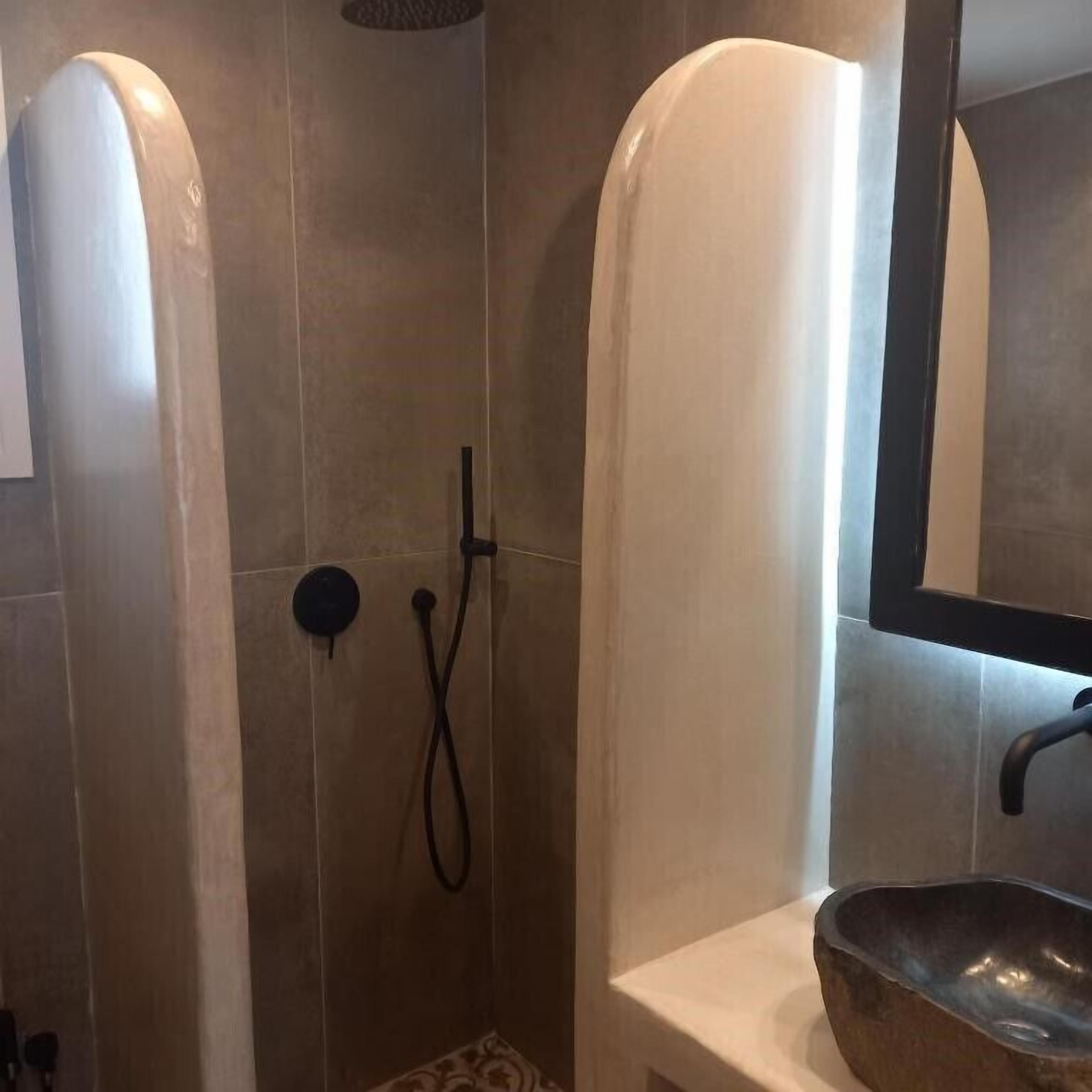 A bathroom with a shower, a sink, and a mirror.