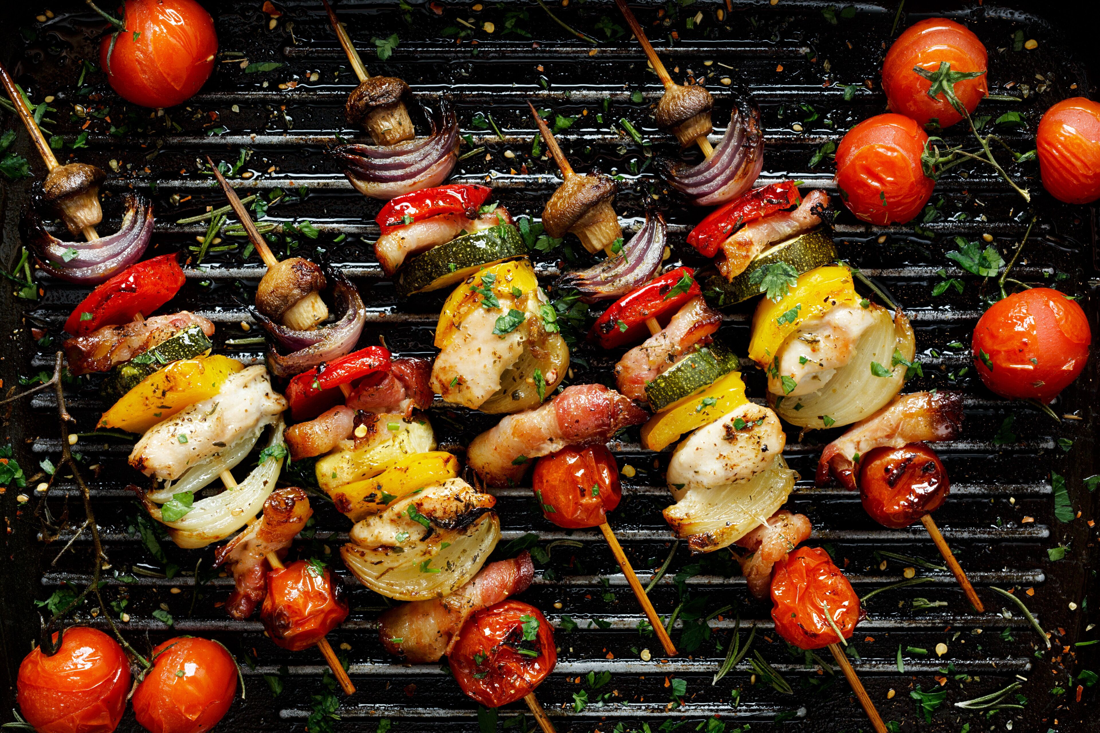 A variety of grilled vegetables and meats on a grill.