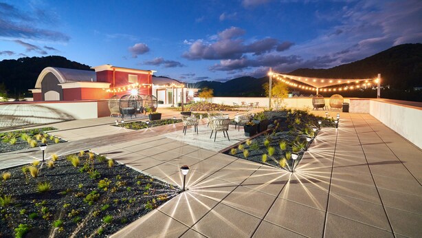 A rooftop patio with outdoor seating, string lights, and a view of the mountains. - Candlewood Suites Asheville Downtown by IHG (Asheville)