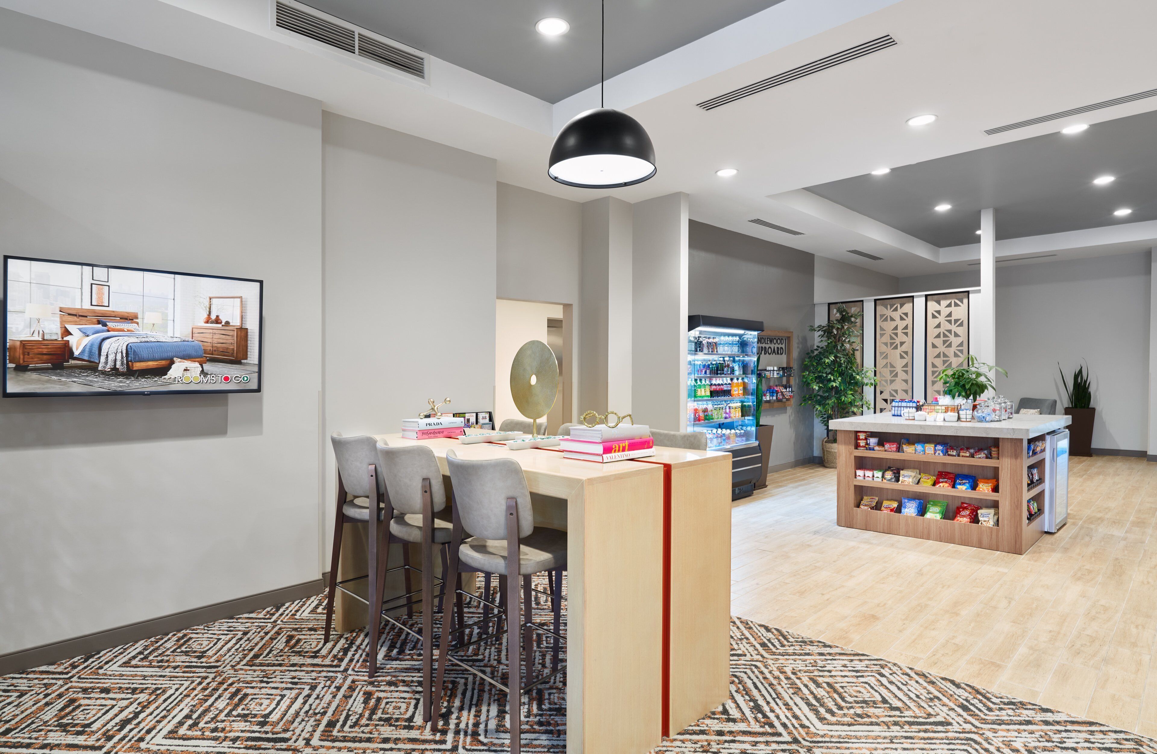 Eine moderne Hotelhalle mit Bar, einer Sitzecke und einer Snackbar.
