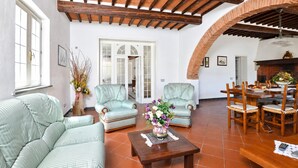 Un amplio salón con techo alto, un comedor y una chimenea.