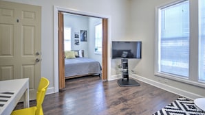 A bedroom with a bed, a TV, a desk, and a chair.