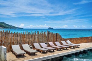 En la playa, arena blanca, sillas reclinables de playa, sombrillas