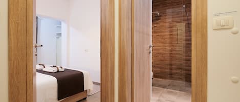 Une chambre d’hôtel avec un lit, une salle de bain avec un mur en bois et un interrupteur sur le mur.
