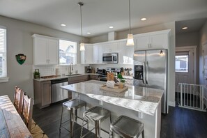 Enjoy cooking in this well-equipped kitchen with a large island, bar stools, and stainless steel appliances.