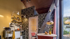 Una cocina con zona de comedor, que incluye una mesa redonda con sillas, una alfombra y vistas al exterior.