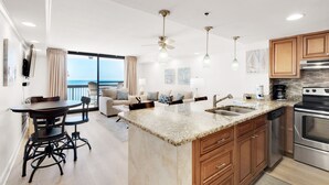 A modern kitchen with granite countertops, wooden cabinets, and stainless steel appliances.