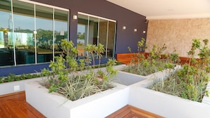 Un espacio exterior moderno con macetas y una terraza de madera.