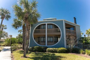 Stunning two-story building with a unique circular balcony and beautifully manicured lawn.