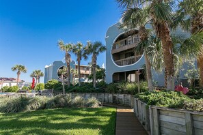 Surrounded by lush greenery, this hotel features curved balconies and a circular window, inviting guests to relax in a serene atmosphere.