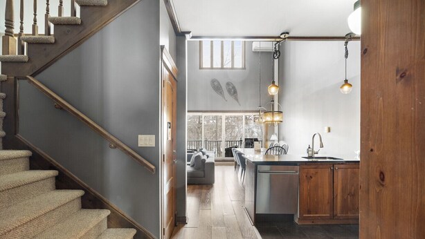 Une cuisine moderne dotée d’un îlot central, de meubles en bois et de luminaires suspendus.