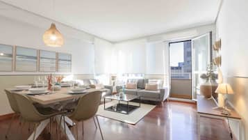 Un salon moderne avec un coin repas, de grandes fenêtres et une vue sur la ville.