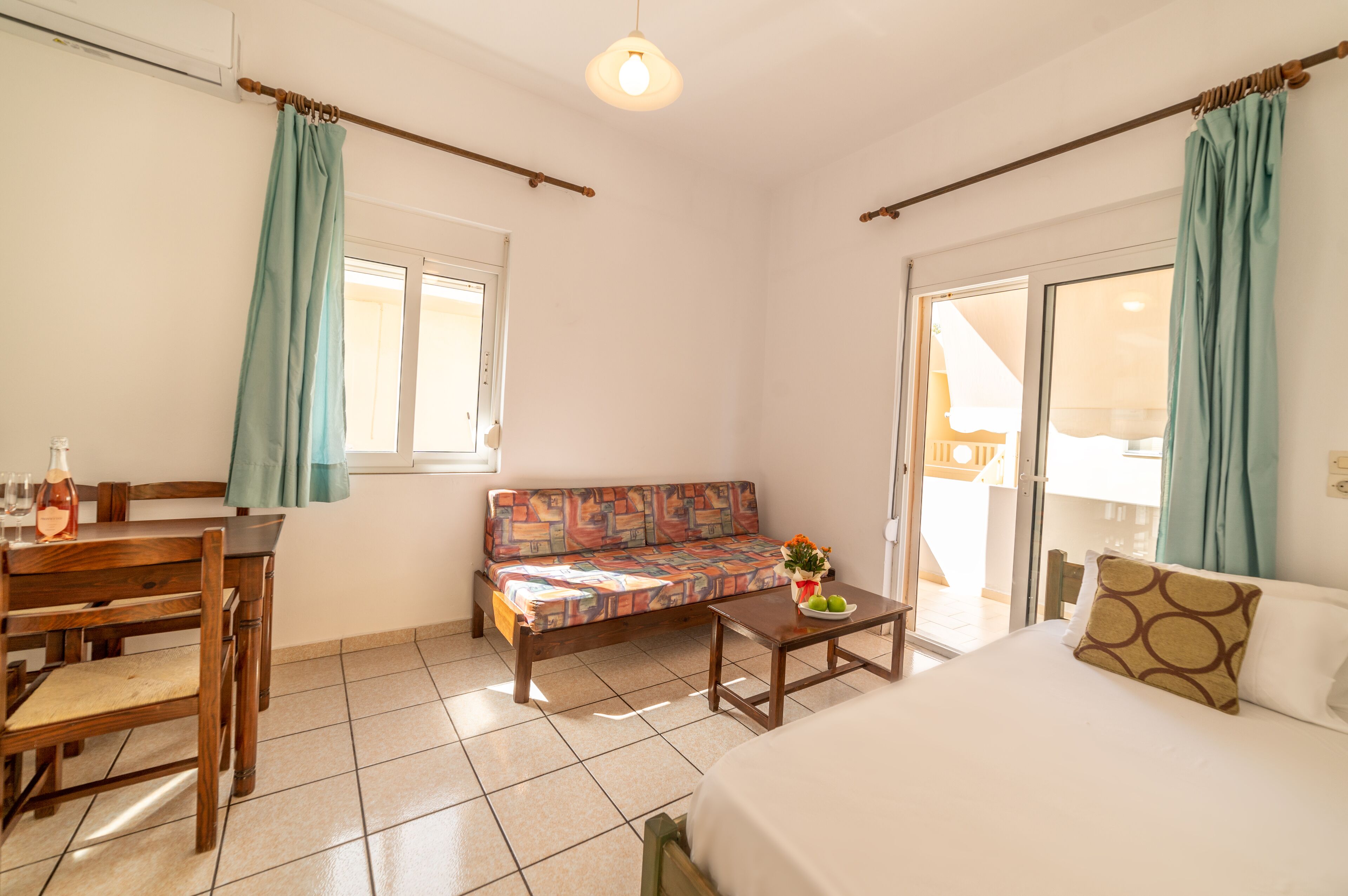 Una habitación compacta con cama, sofá, mesa de comedor y una mesita de centro.