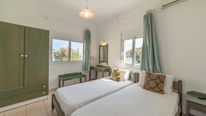 Une chambre avec deux lits, un bureau, un miroir et une armoire.