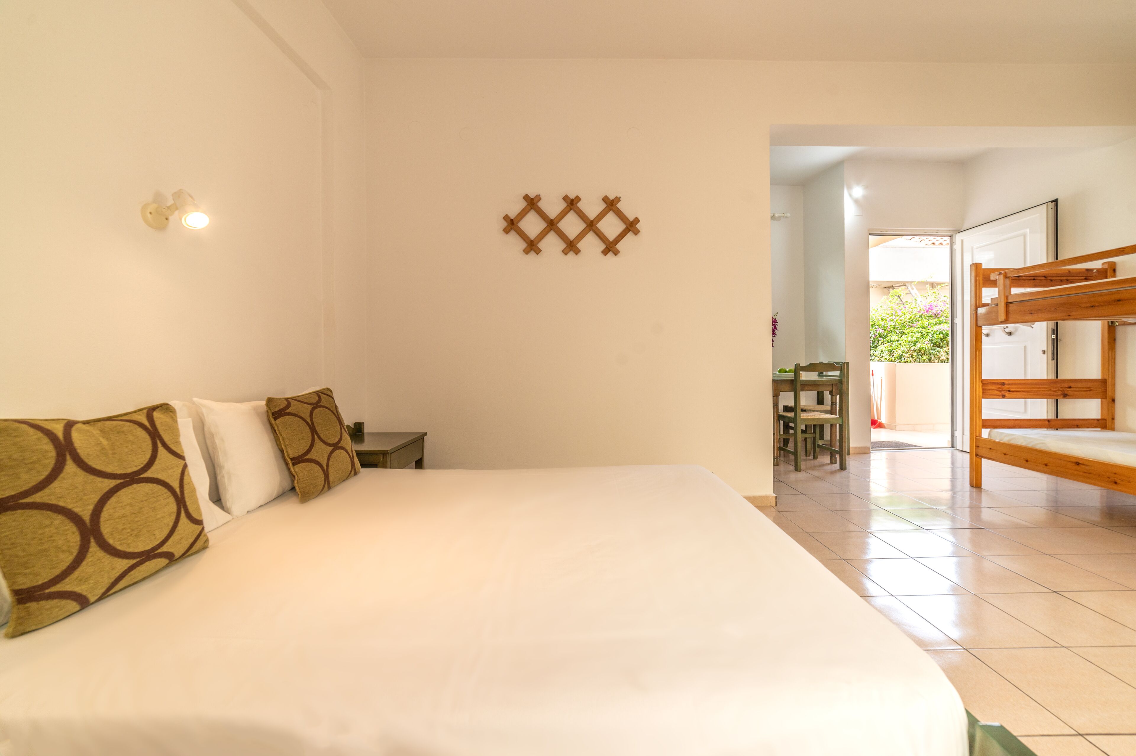 Una habitación de hotel con una cama grande, un escritorio, una silla y una litera.