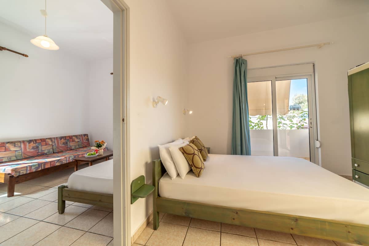 Un dormitorio con una cama, un banco y vistas al exterior.