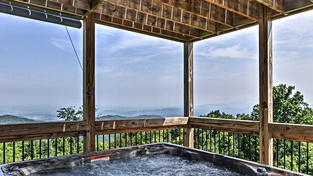 A hot tub with a wooden deck and a scenic mountain view. - Sunrise Above Ober, Hot Tub and Two Decks (Gatlinburg)