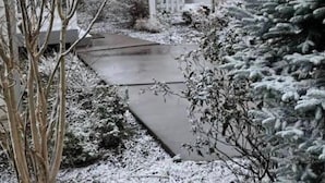 A residential area with houses, a pathway, and snow-covered vegetation. - Sunrise Above Ober, Hot Tub and Two Decks (Gatlinburg)