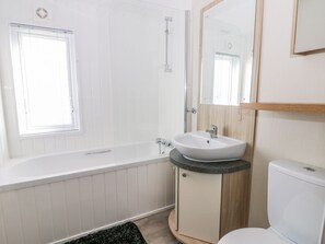 A modern bathroom with a bathtub, a sink, and a toilet.