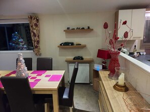 A cozy dining area with a wooden table, black chairs, and a Christmas tree. - Superb Detached Lodge Located on Skipsea Sands (Driffield)