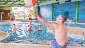 An indoor swimming pool with a tiled floor, a lifeguard tower, and a mural of marine life on the wall. - Superb Detached Lodge Located on Skipsea Sands (Driffield)