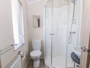 A bathroom with a toilet, a glass-enclosed shower, and a sink. - Superb Detached Lodge Located on Skipsea Sands (Driffield)