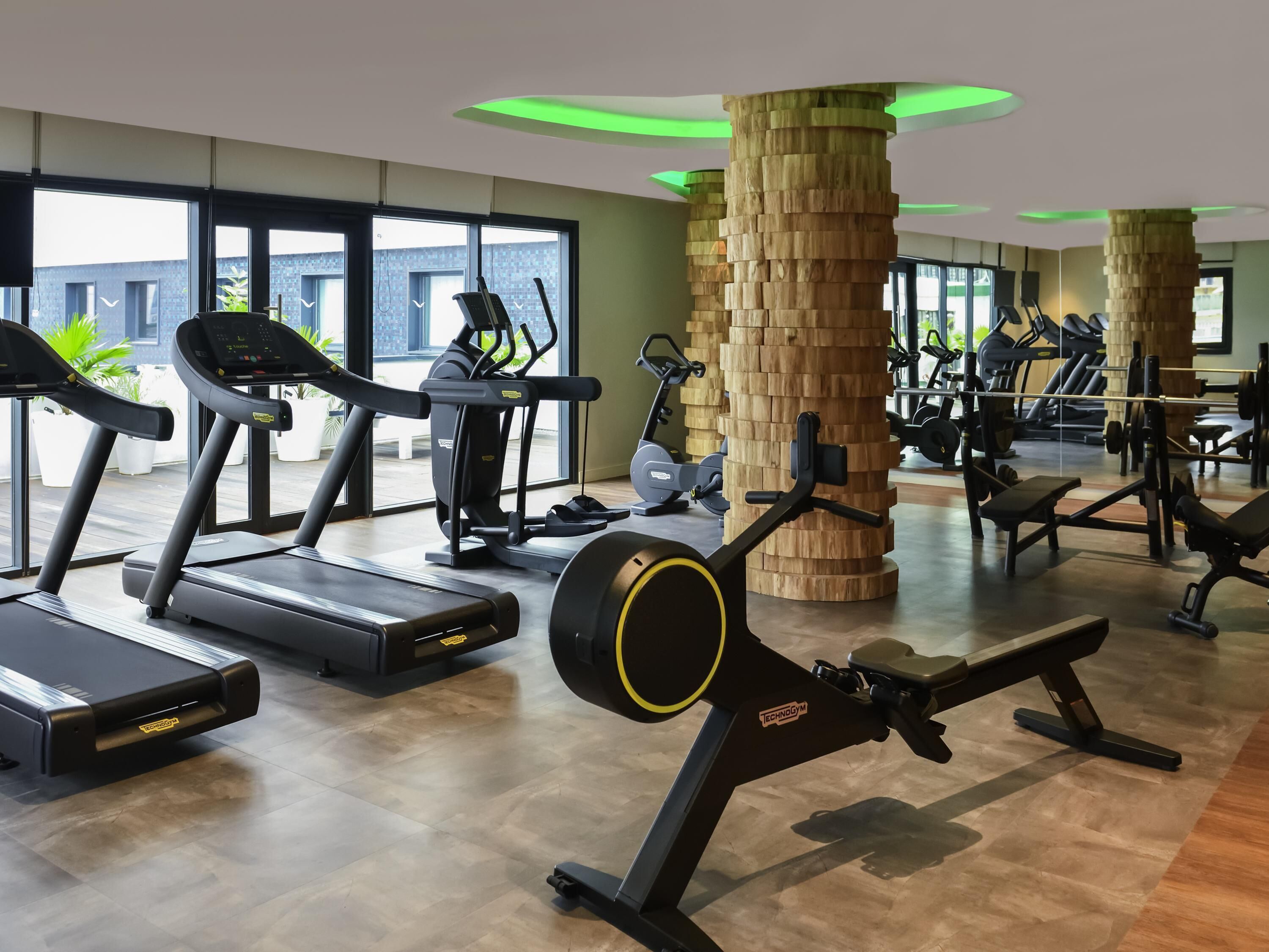 A gym with treadmills, elliptical machines, and weightlifting equipment.