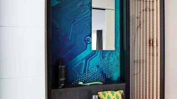 Un baño con espejo, lavamanos, grifo, dispensador de jabón y toalla con estampado de cactus.