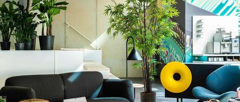 A modern living area with a sofa, a coffee machine, and a staircase.